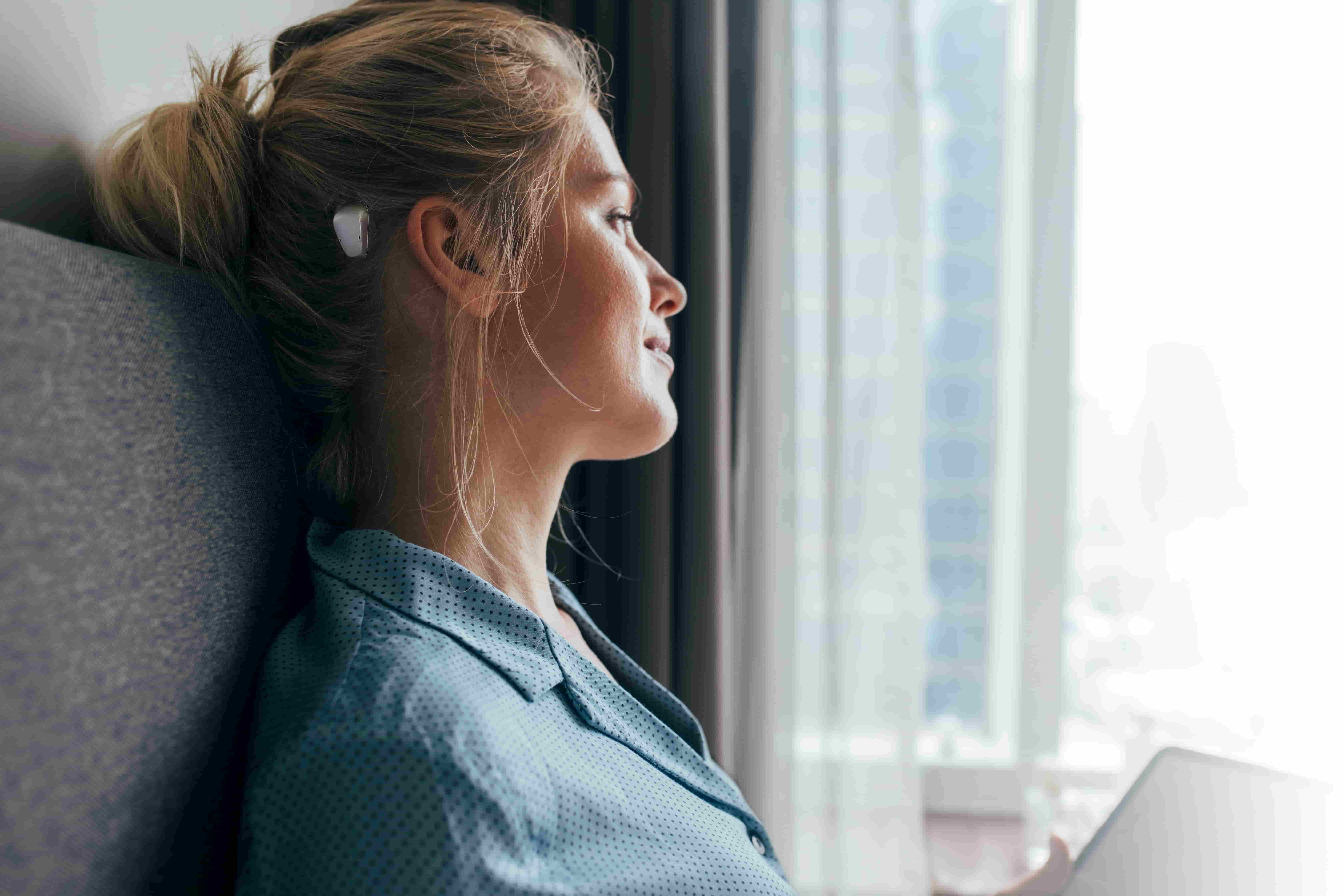 Women looking out window wearing cochlear implant